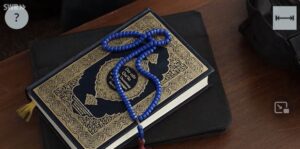 Bild zeigt Koran und Gebetskette. Still aus dem Video Sebastian wird Salafist.