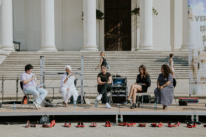 Fünf Personen sitzen auf einer Bühne vor der Karlskirche und diskutieren. 